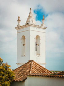 a tall white tower with a clock on top of it