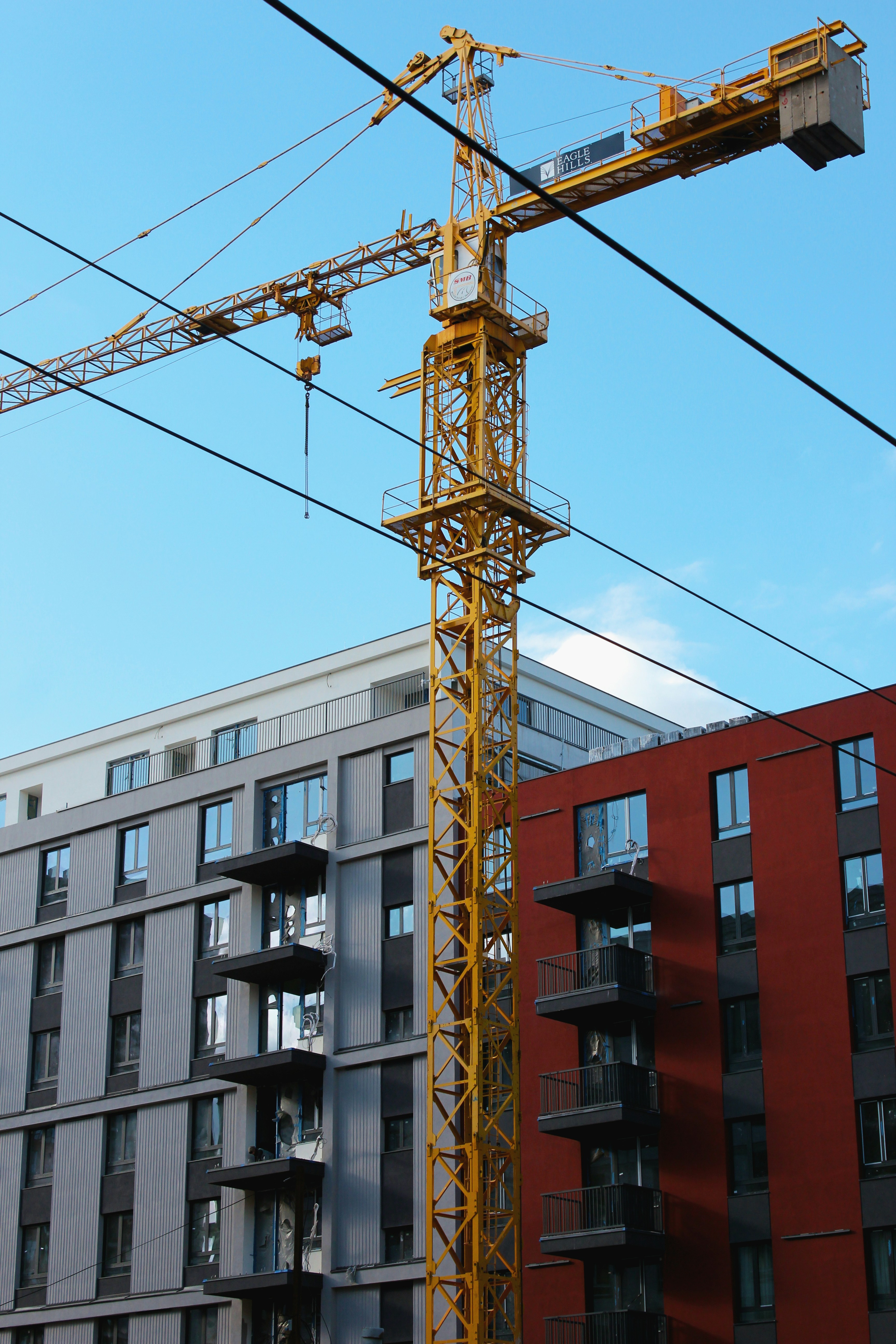 a yellow crane sitting next to a tall building