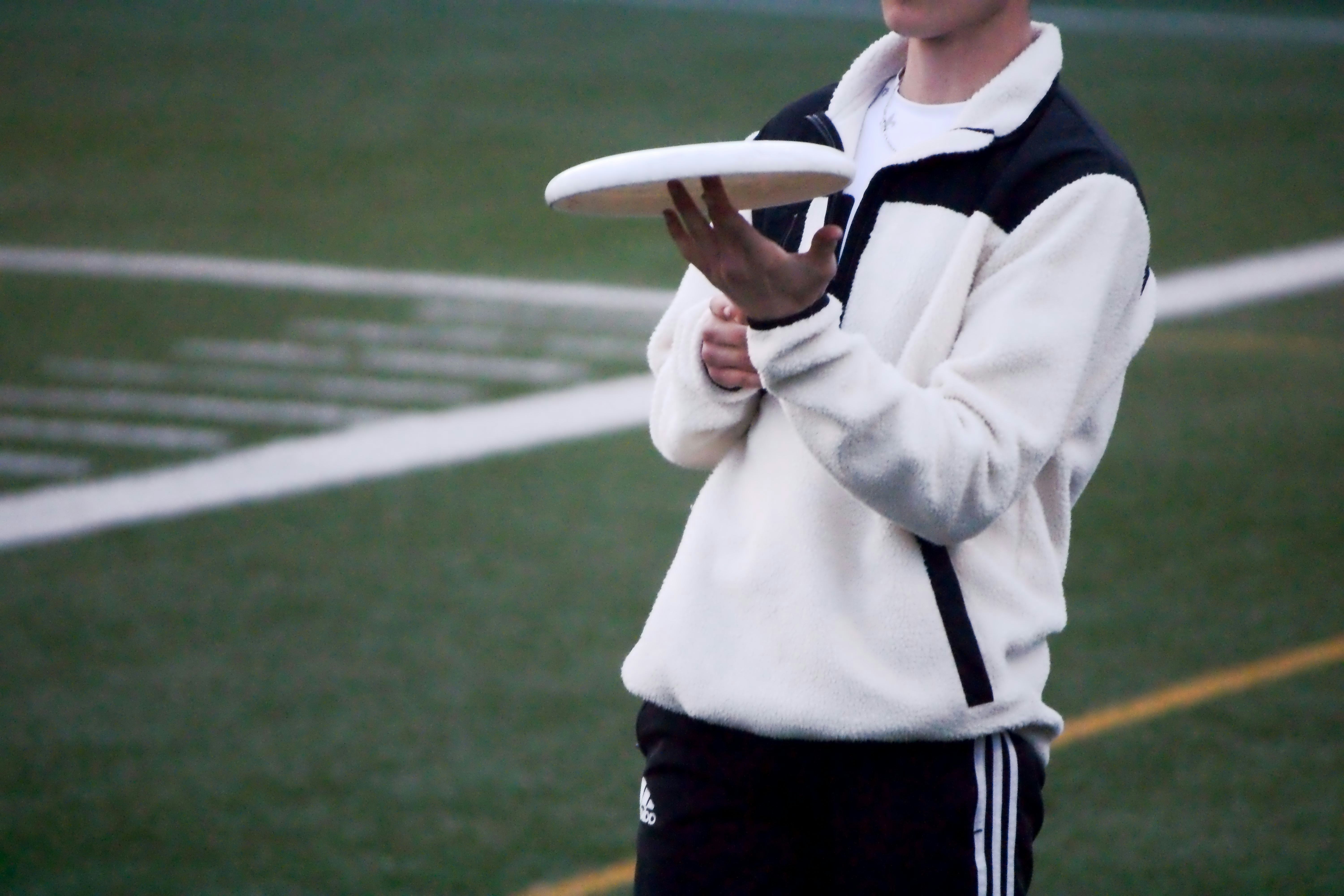 a young boy holding a frisbee on top of a field