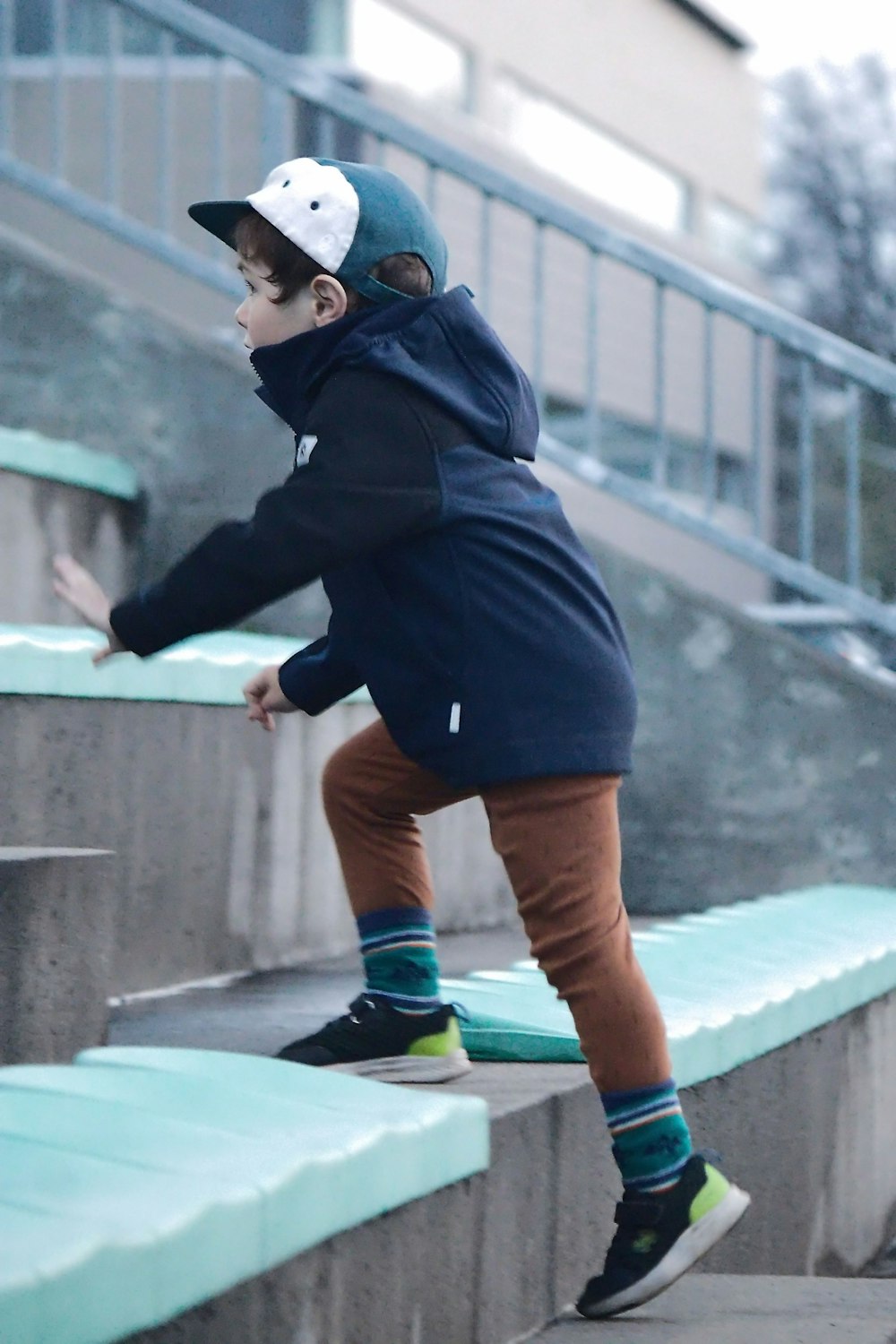 セメントの階段の脇をスケートボードで下る青年