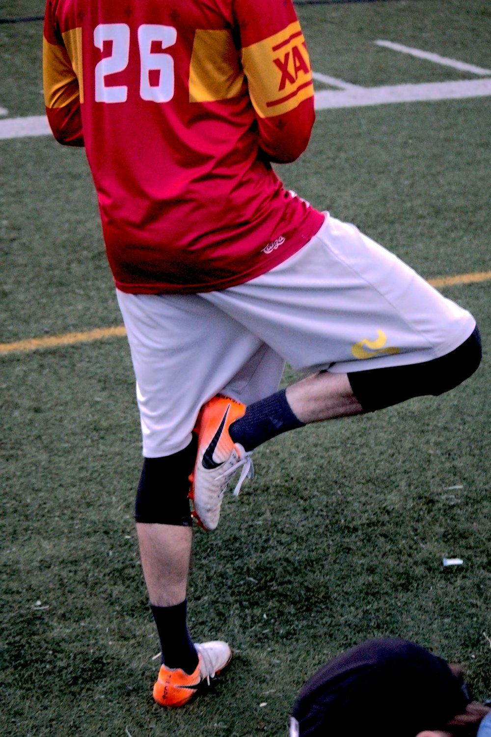 a man in a red and yellow uniform kicking a soccer ball