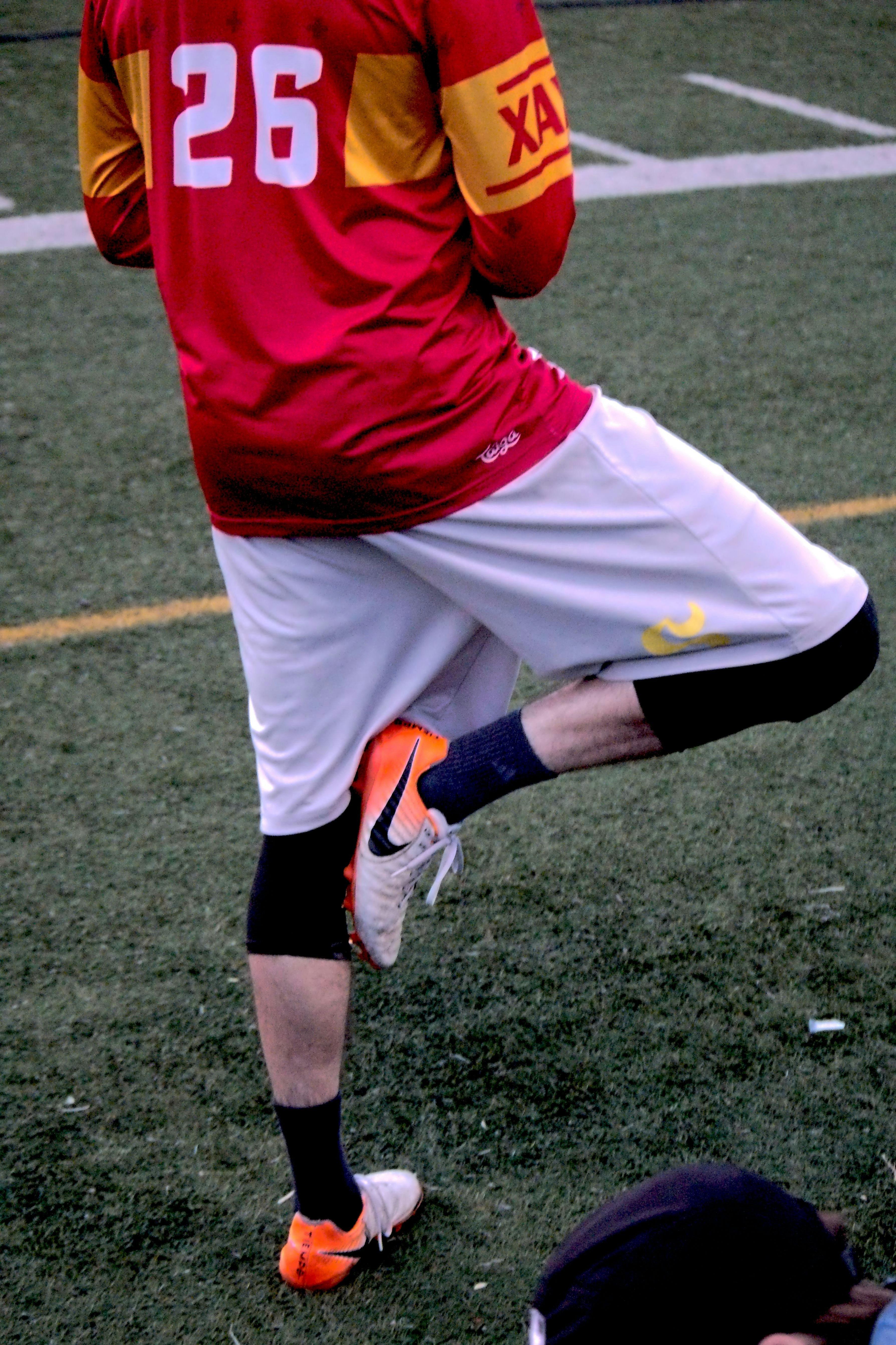 a man in a red and yellow uniform kicking a soccer ball
