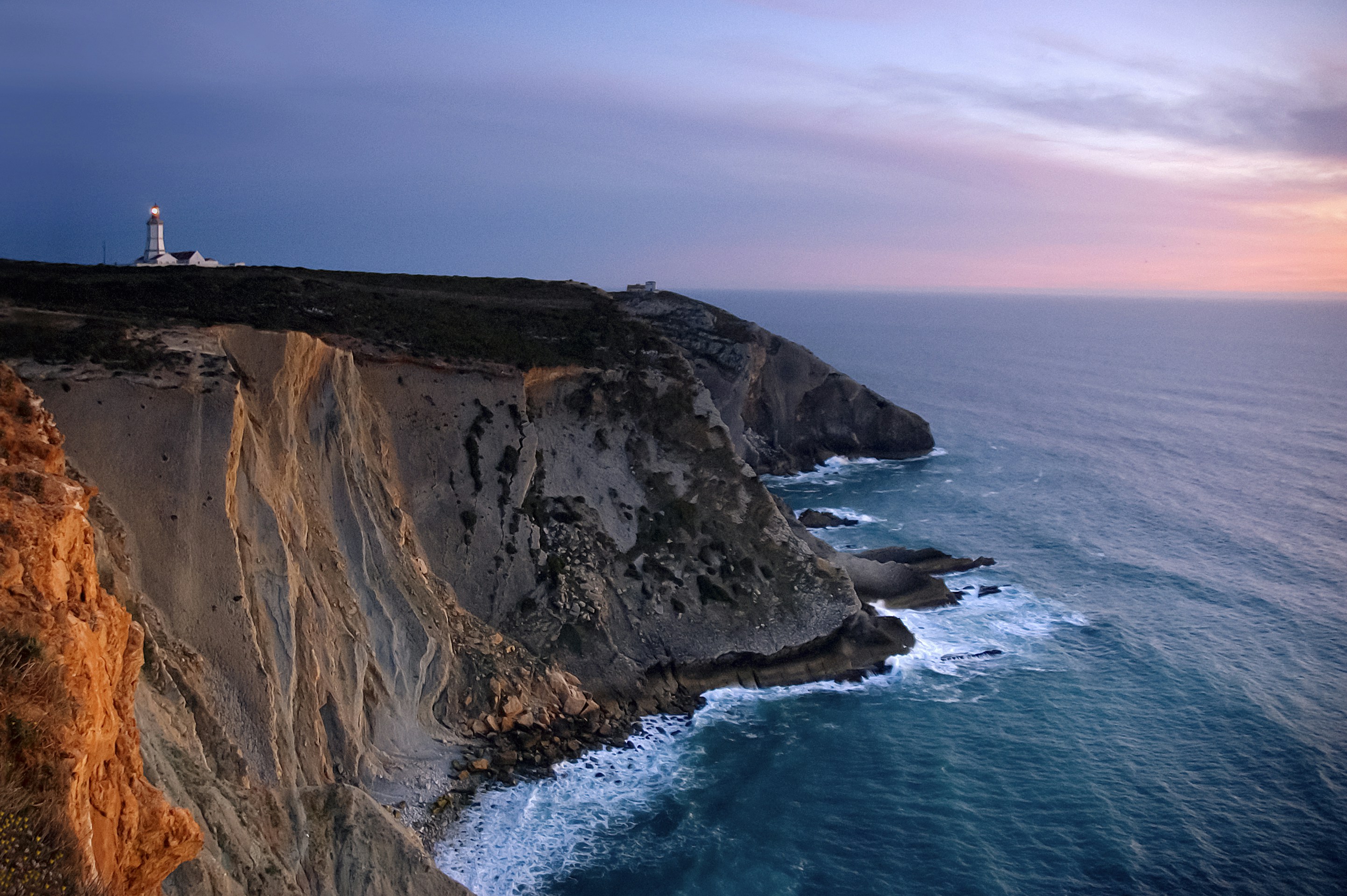 a lighthouse on top of a cliff overlooking the ocean