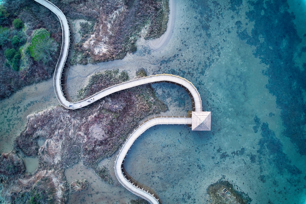 an aerial view of a winding road in the ocean