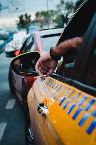 a man is holding his hand out of a car window
