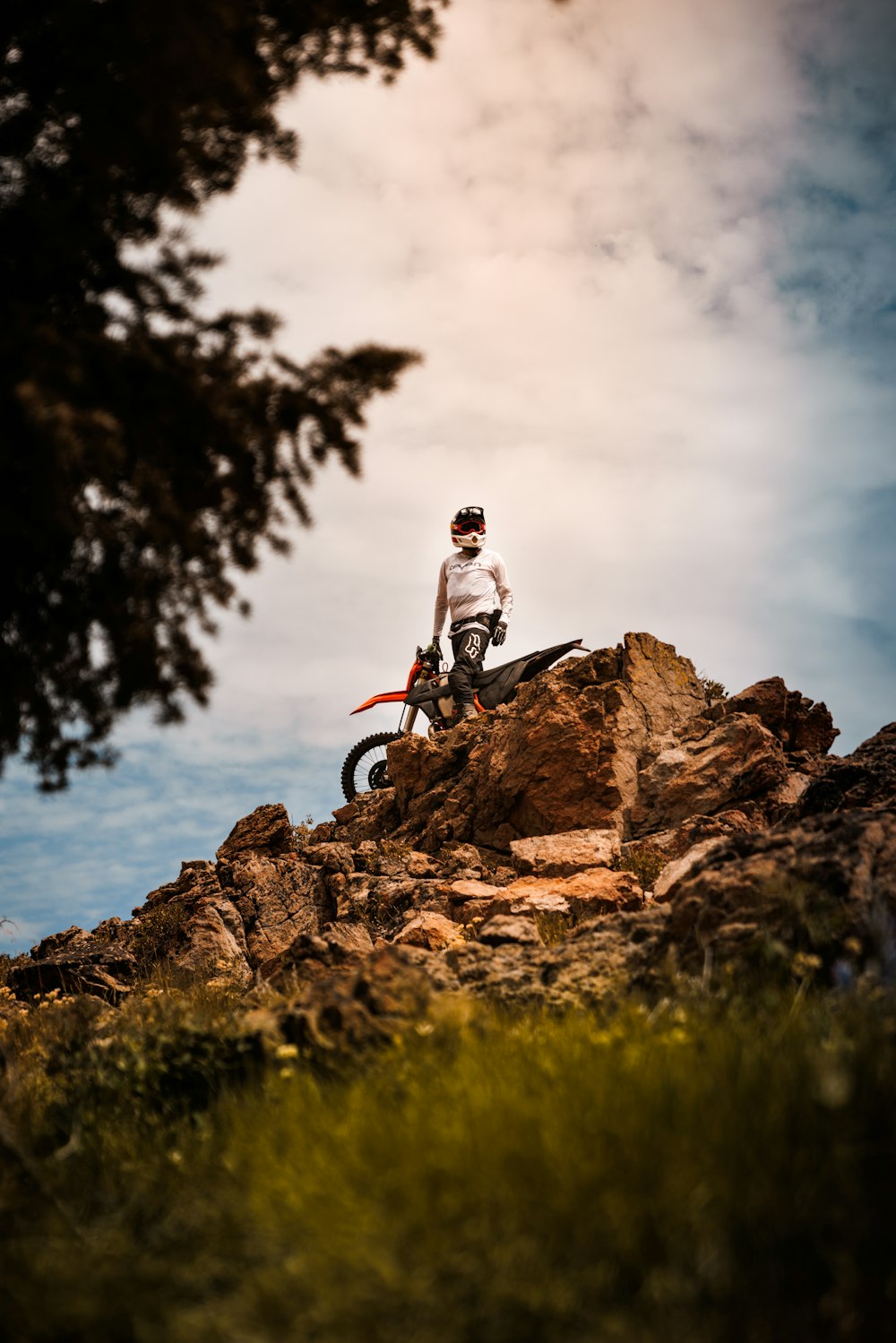 a man riding a dirt bike on top of a rocky hill