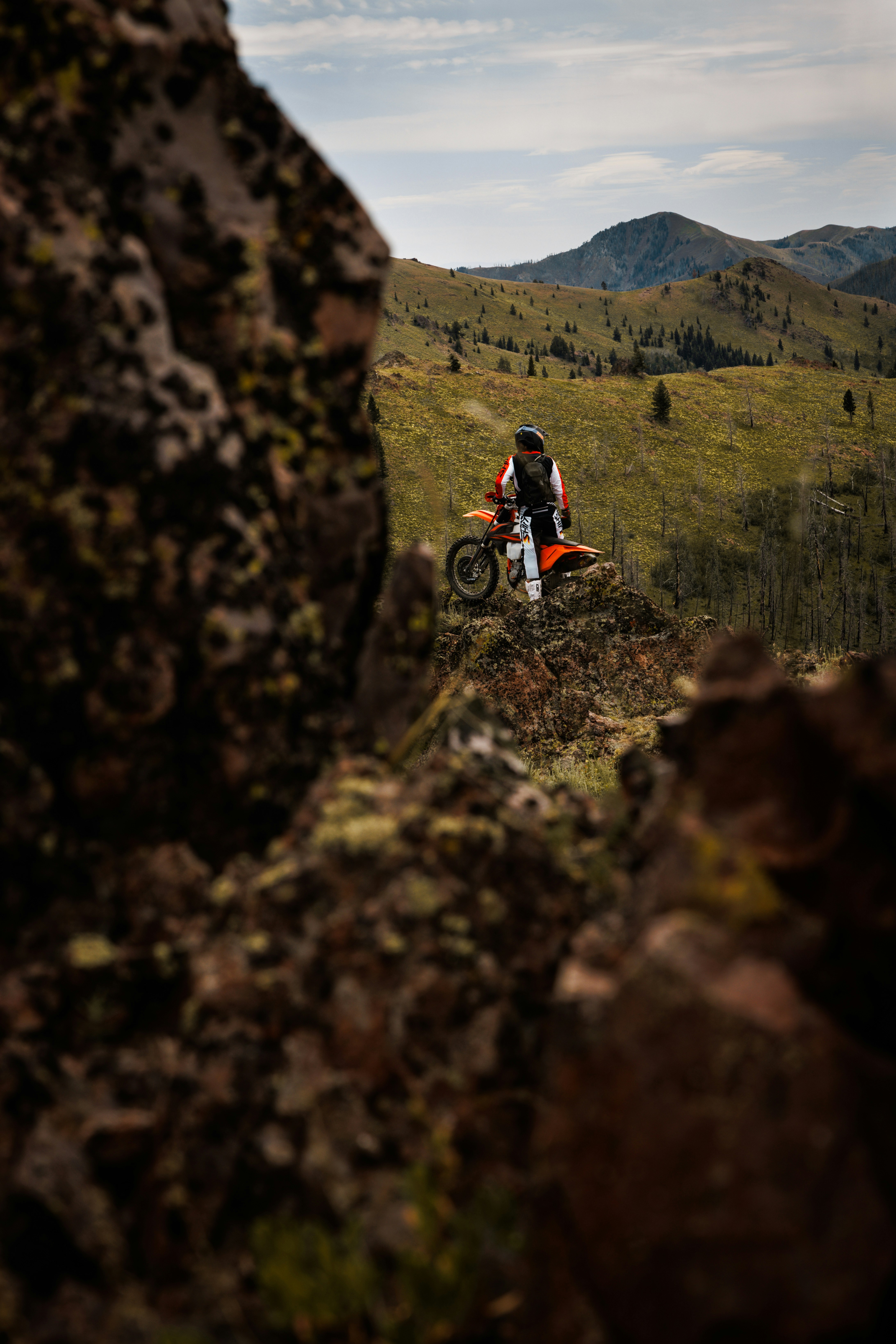 un homme conduisant une moto tout-terrain au sommet d’une colline