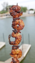 a close up of a skewer of food near a body of water