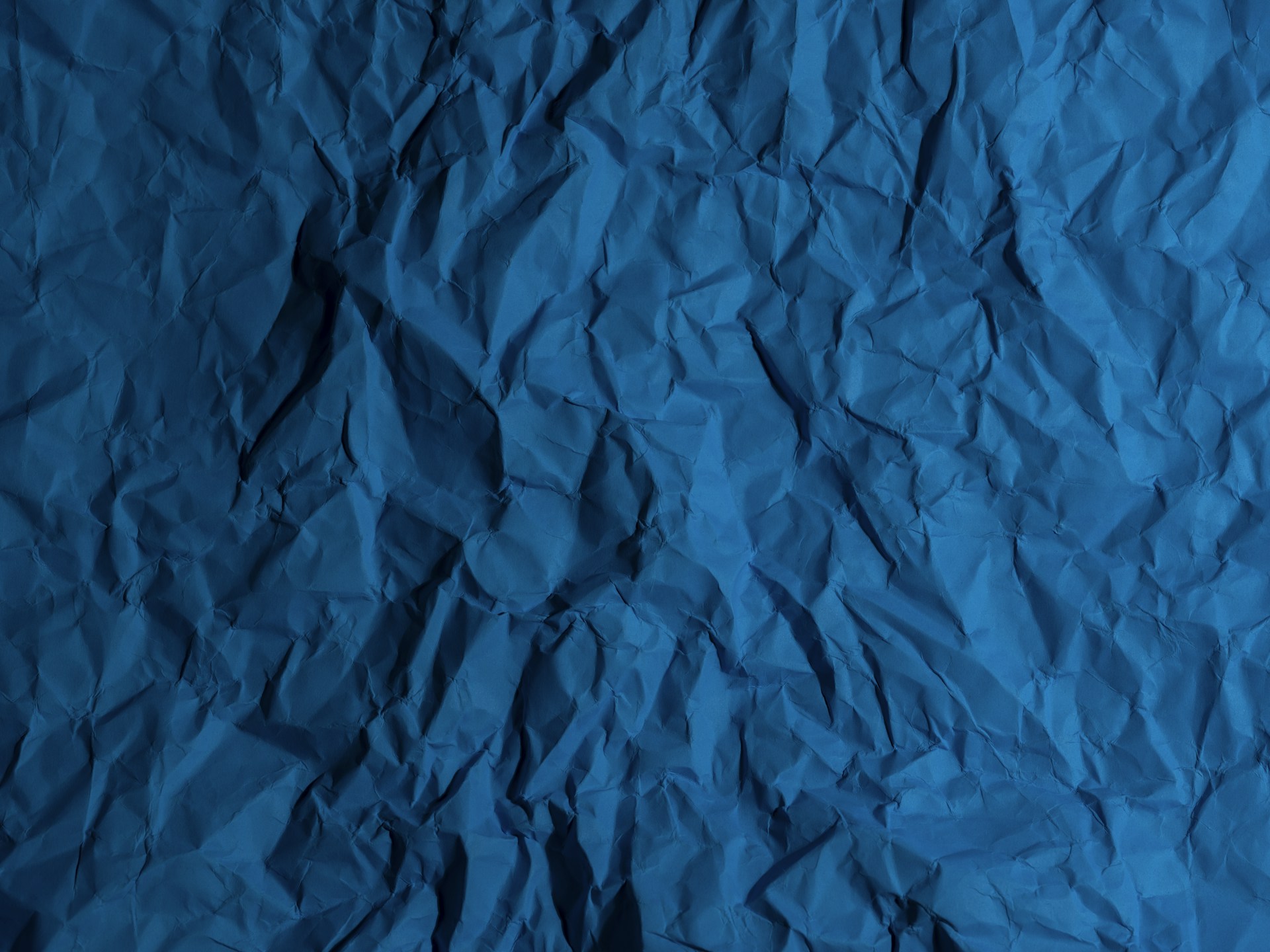 a piece of blue paper that is crumpled in half