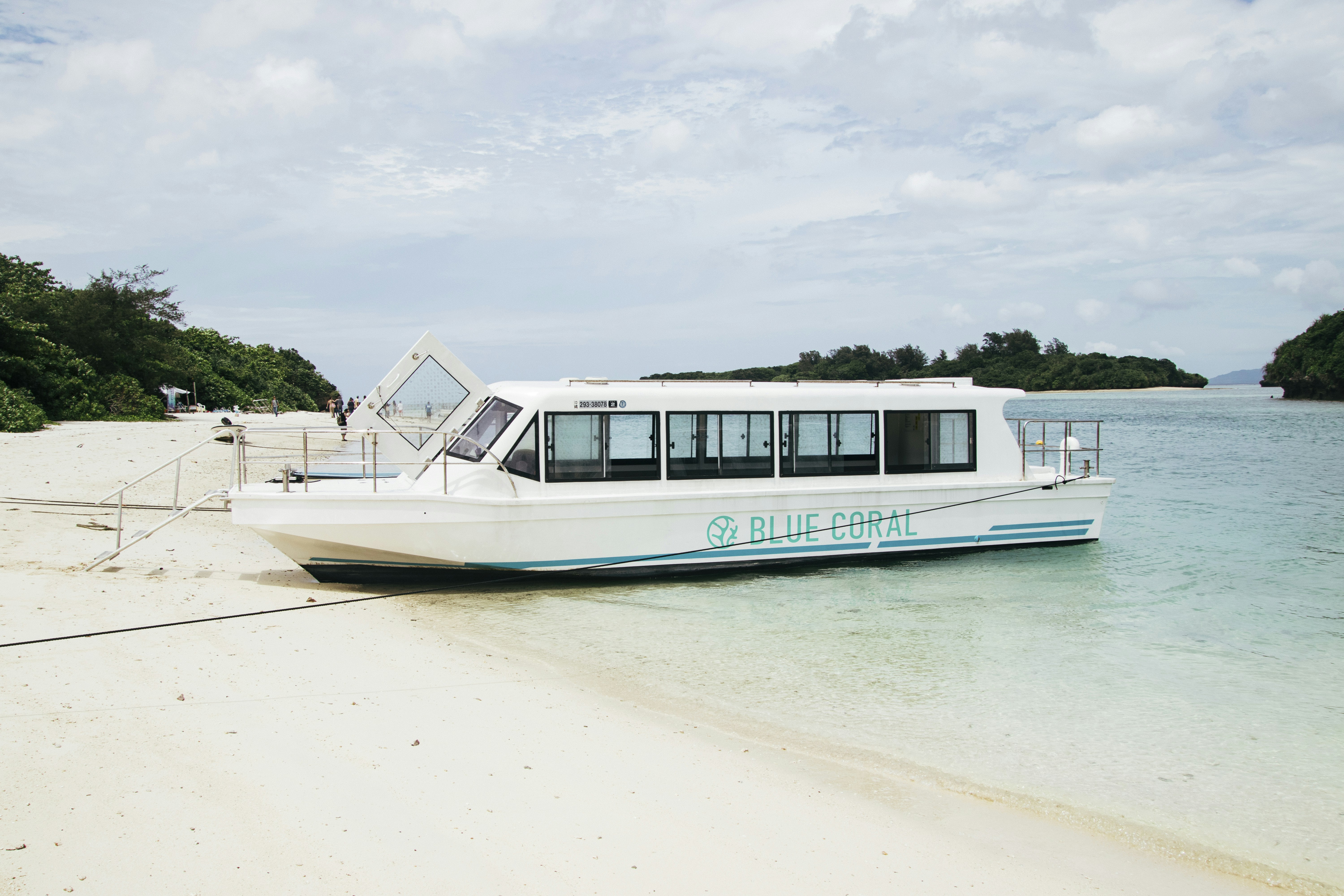 a white boat sitting on top of a sandy beach