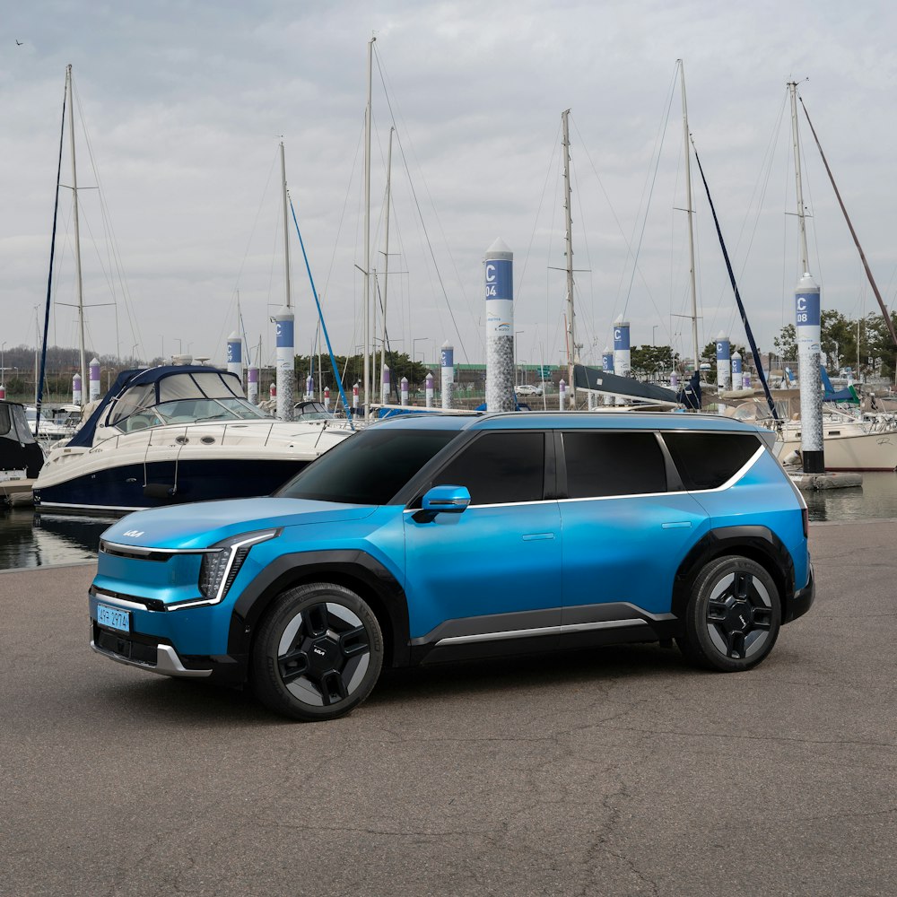 a blue suv parked in front of a boat dock
