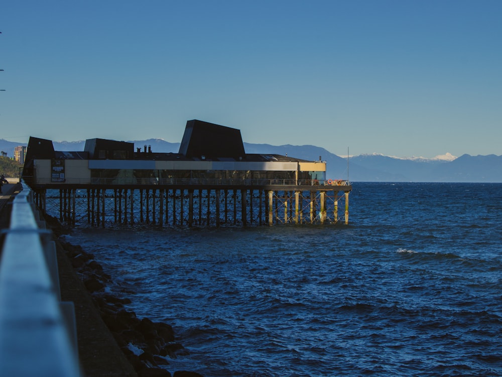 a pier on the water with mountains in the background