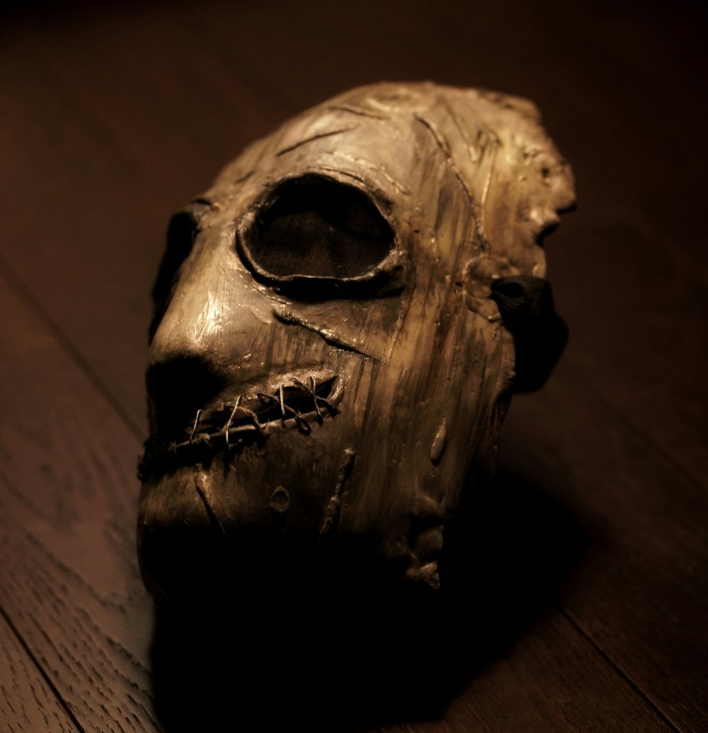 a wooden carved skull on a wooden floor