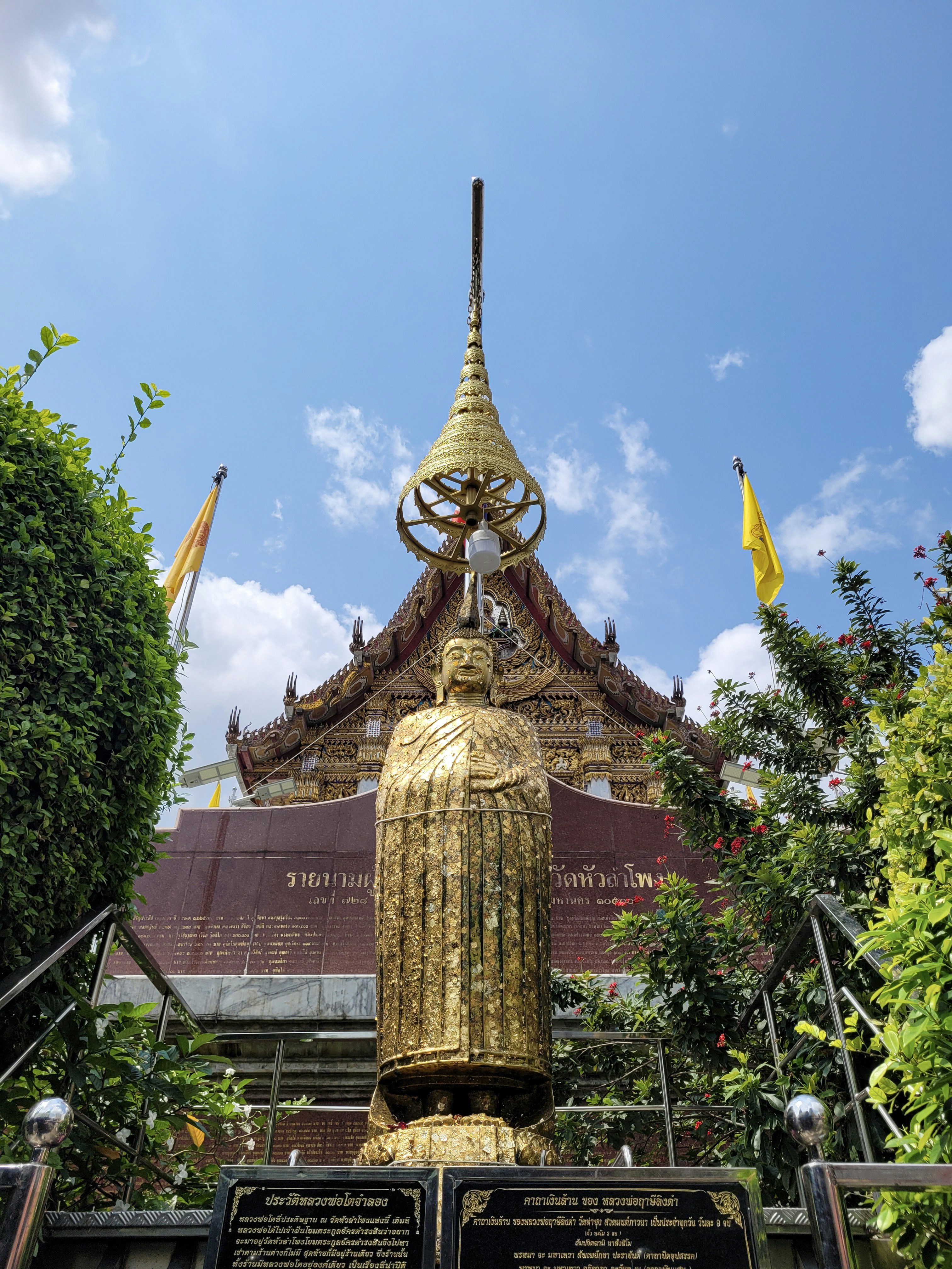 a statue of a woman in a golden dress in front of a building