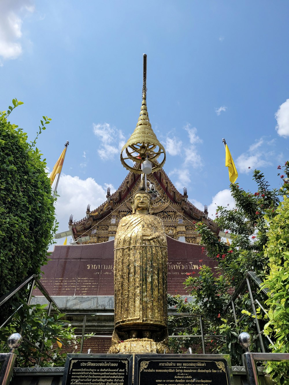 a statue of a woman in a golden dress in front of a building