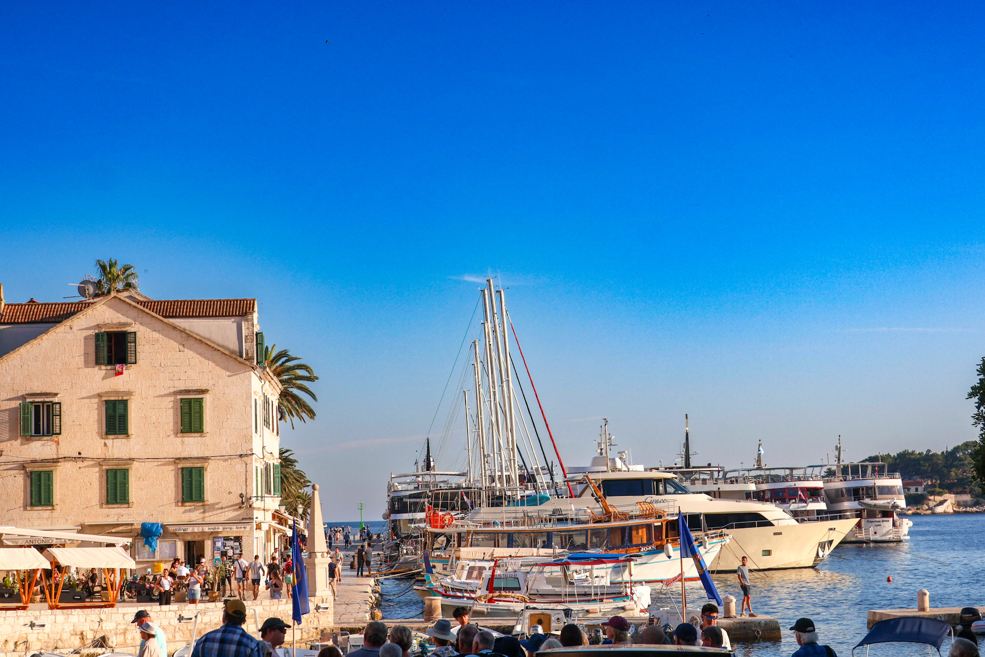 a group of people standing on a pier next to a body of water