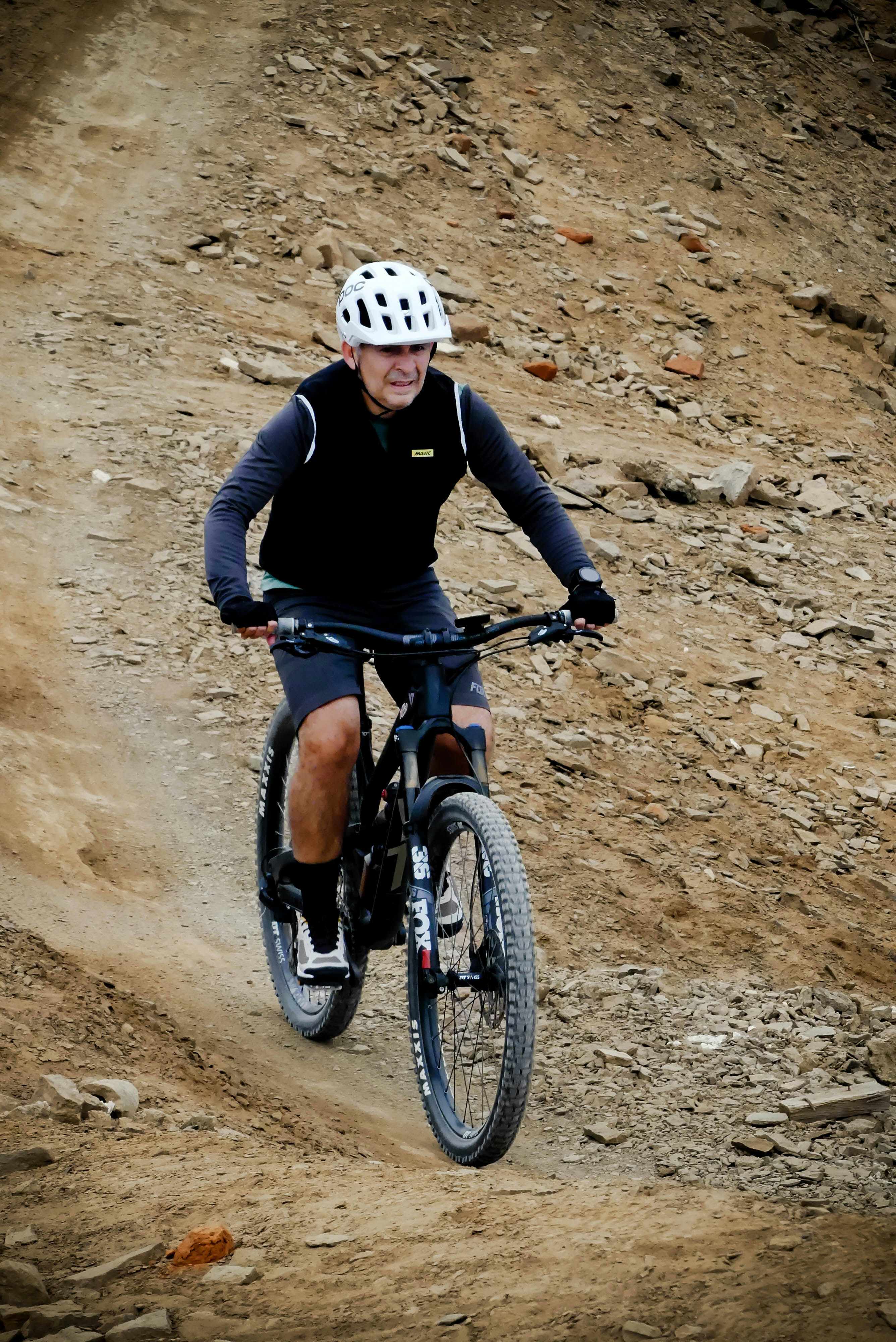 a man riding a bike down a dirt road
