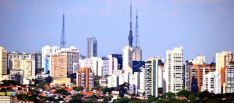a city skyline with tall buildings and a blue sky