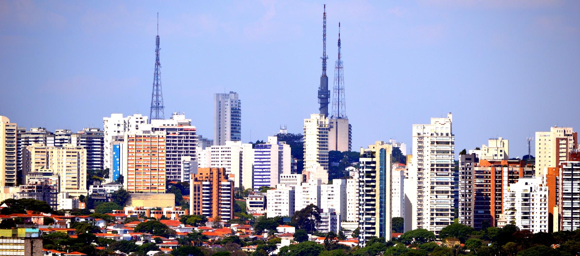 a city skyline with tall buildings and a blue sky