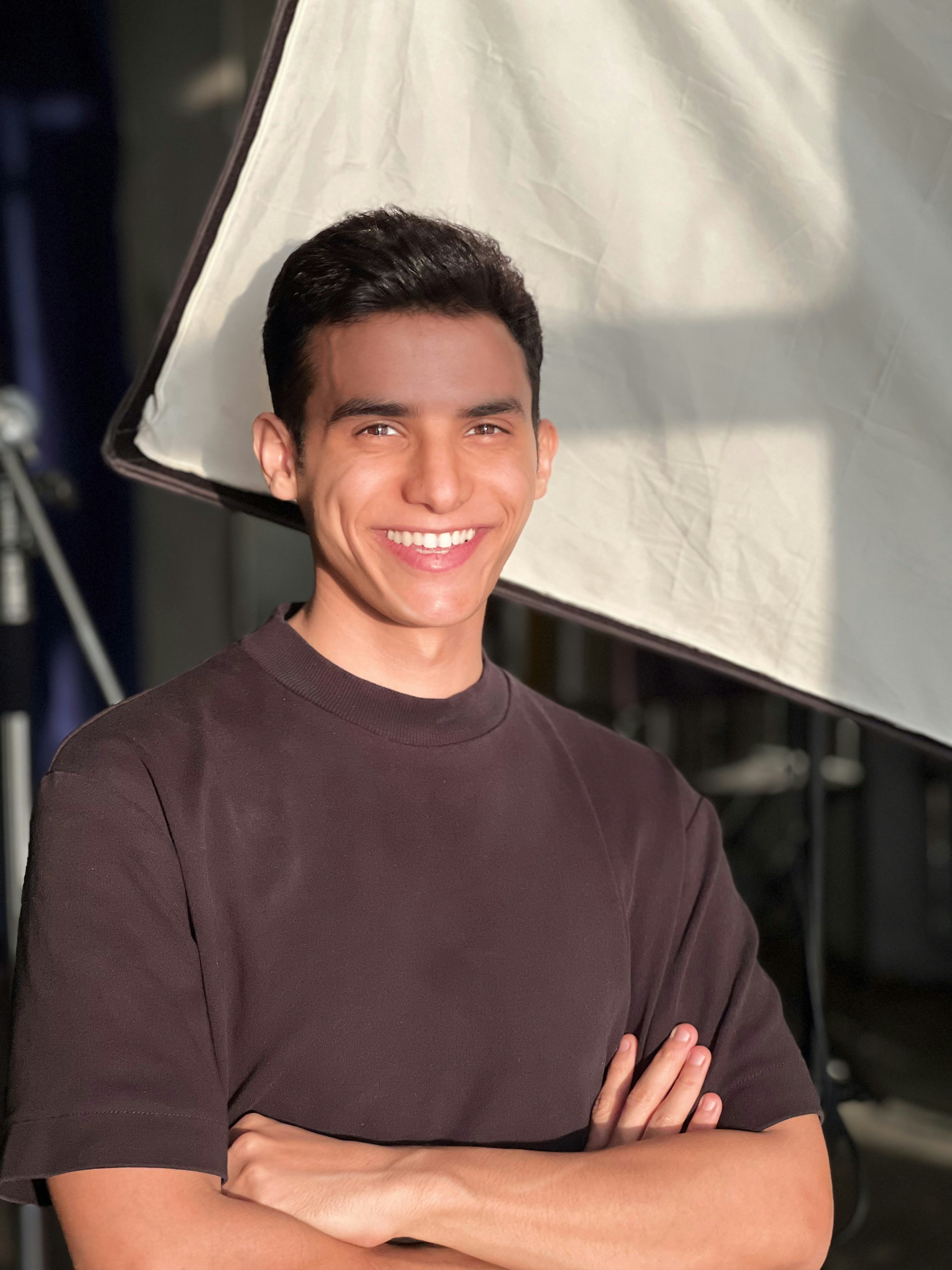 a man standing in front of a camera with his arms crossed