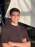 a man standing in front of a camera with his arms crossed