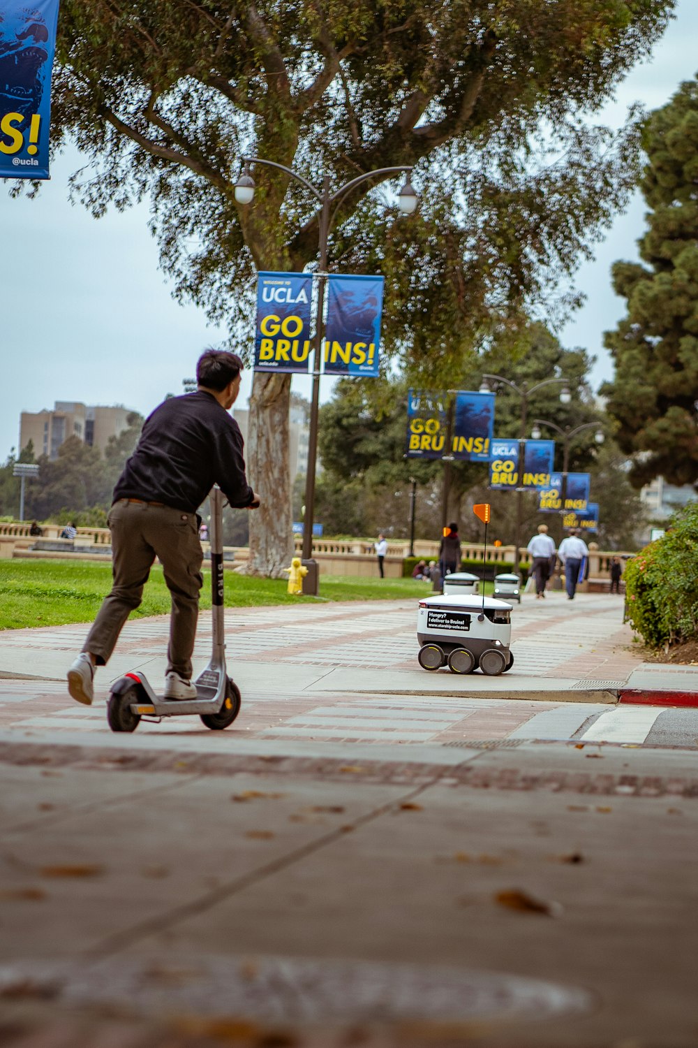 a man riding a scooter down a sidewalk