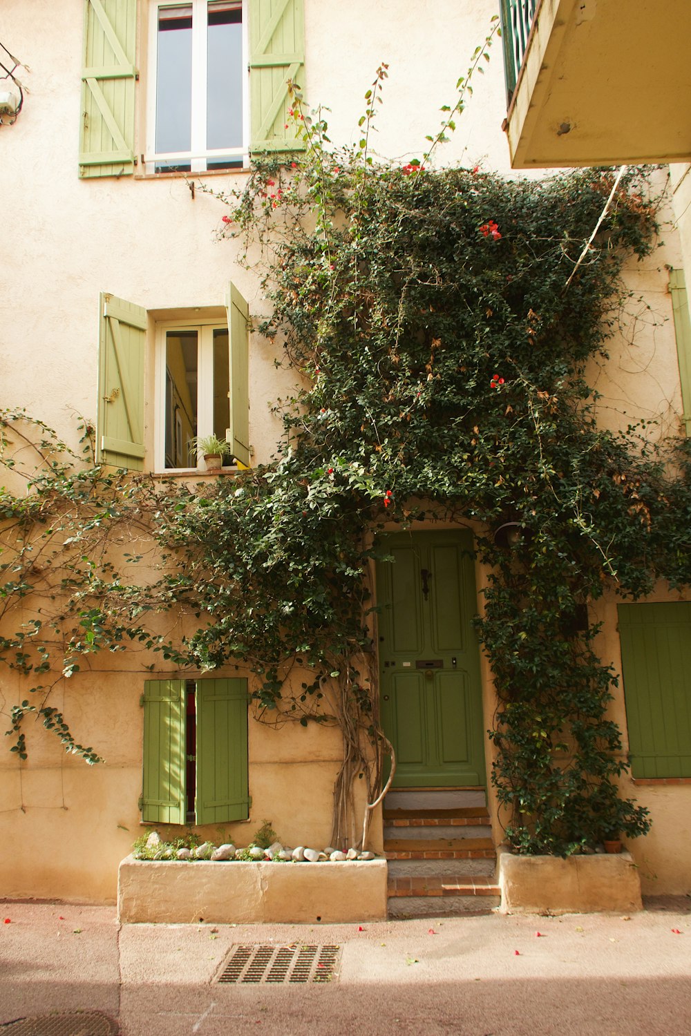 Un edificio con persianas verdes y una puerta verde