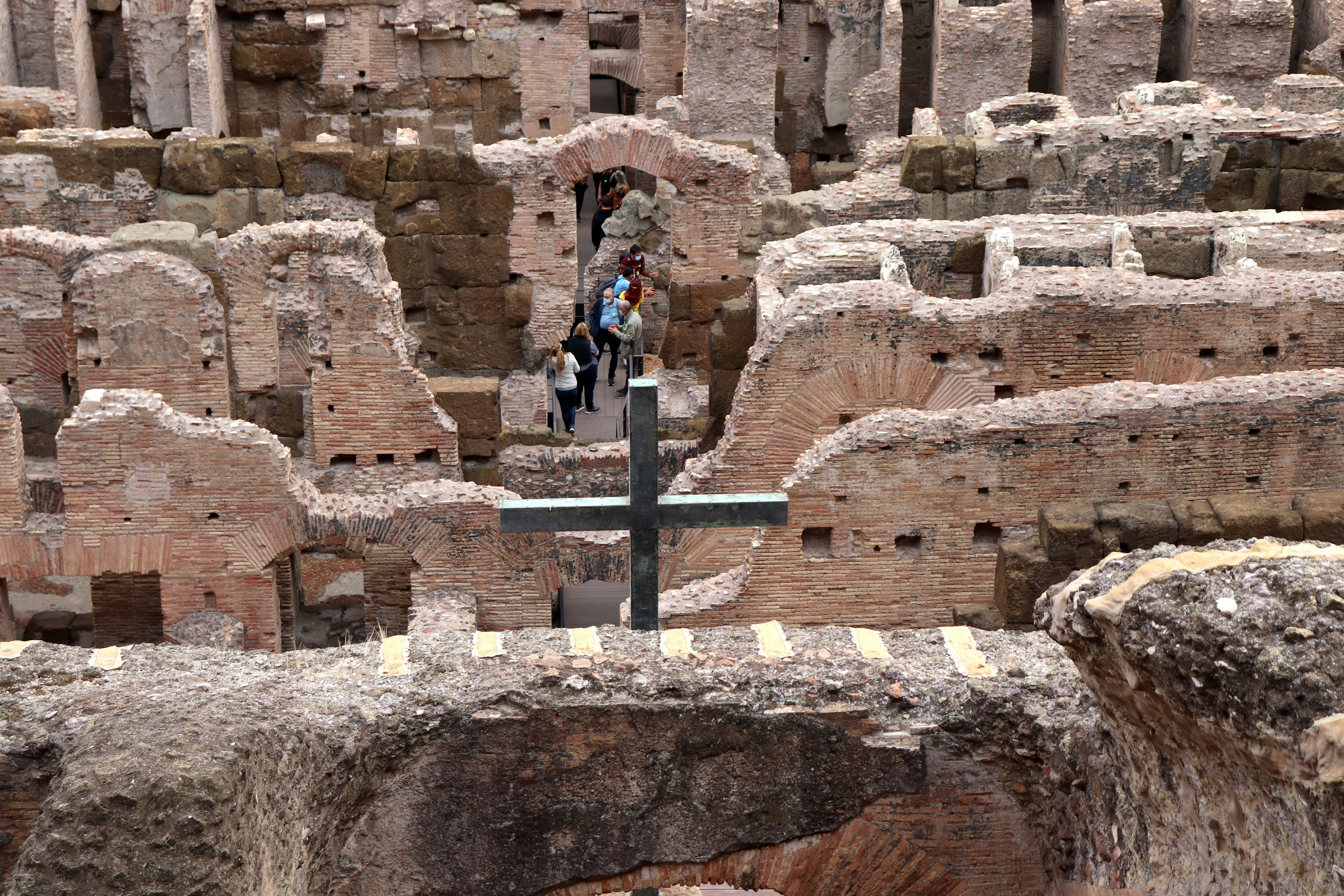 a cross in the middle of a large group of ruins