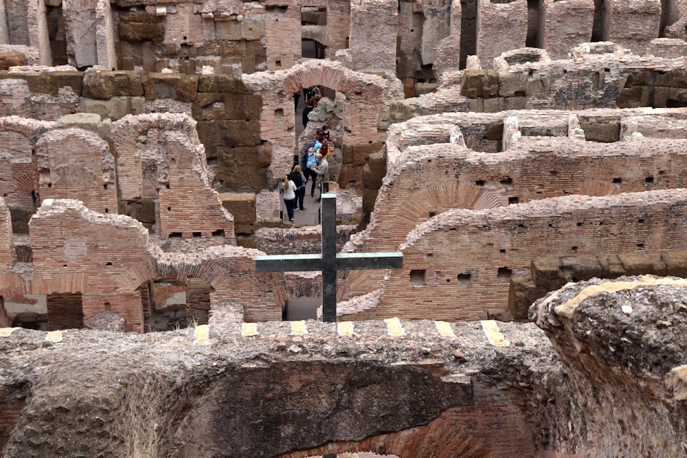 a cross in the middle of a large group of ruins