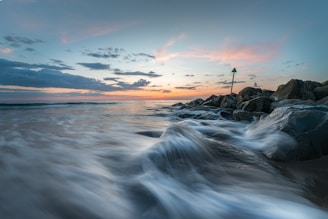 a long exposure photo of a beach at sunset