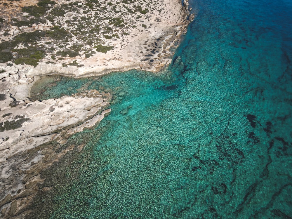 an aerial view of a body of water next to a cliff