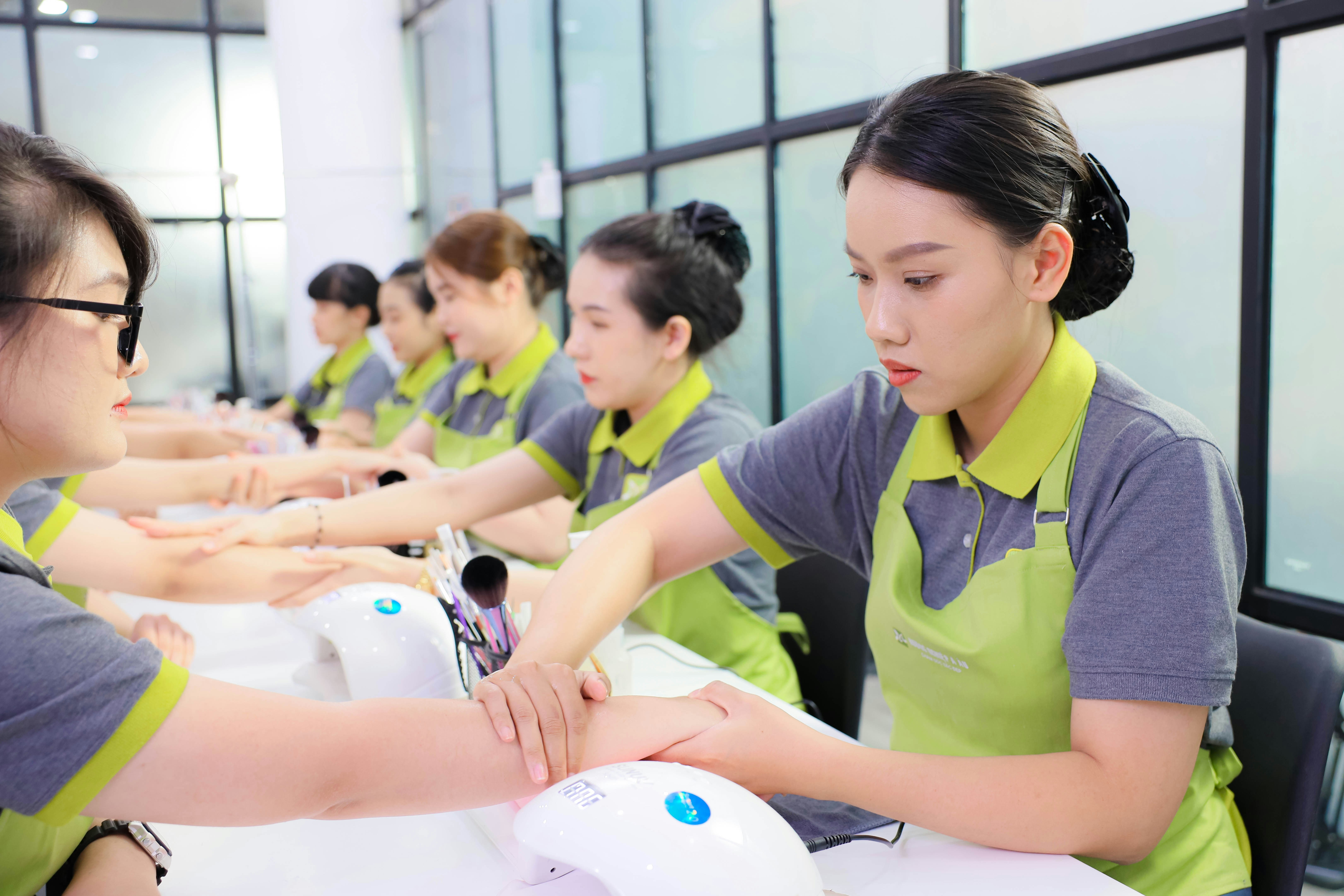 Women learning beauty techniques at training table