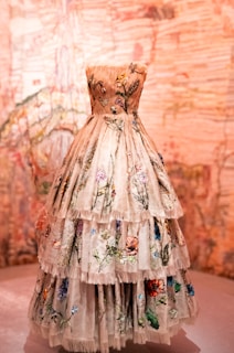 a dress is displayed on a pedestal in front of a wall