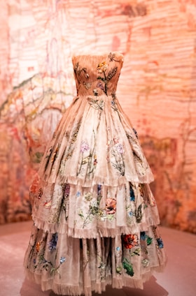 a dress is displayed on a pedestal in front of a wall