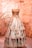 a dress is displayed on a pedestal in front of a wall