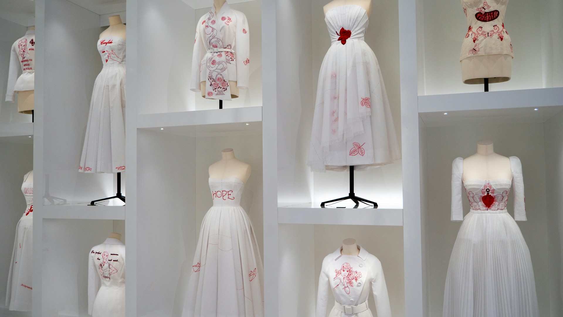a bunch of dresses are on display in a room