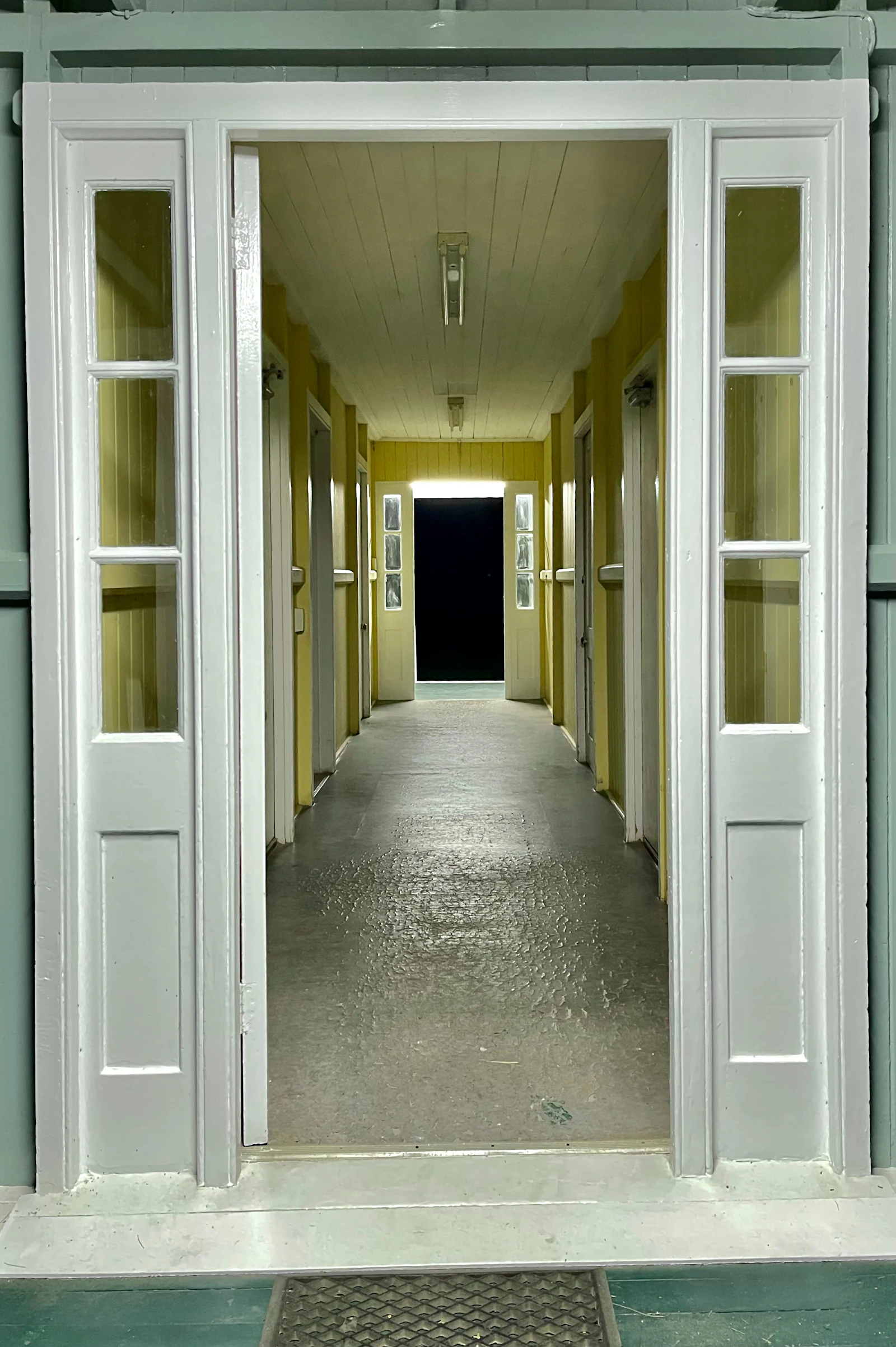 An open door leading into a long hallway