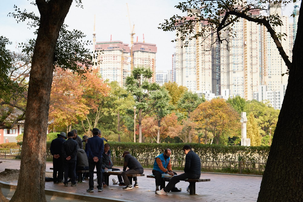 a group of people sitting on a bench in a park