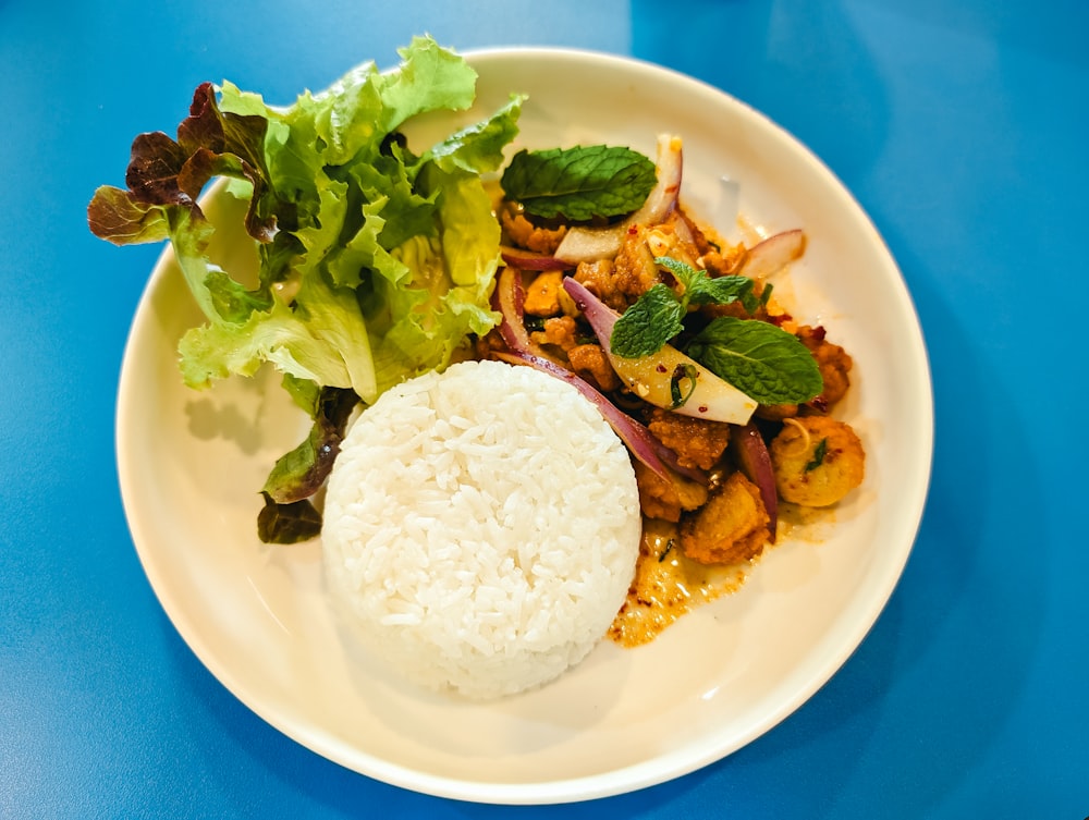 a white plate topped with rice and vegetables