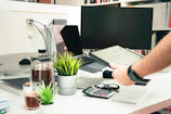a man is holding a tablet while sitting at a desk