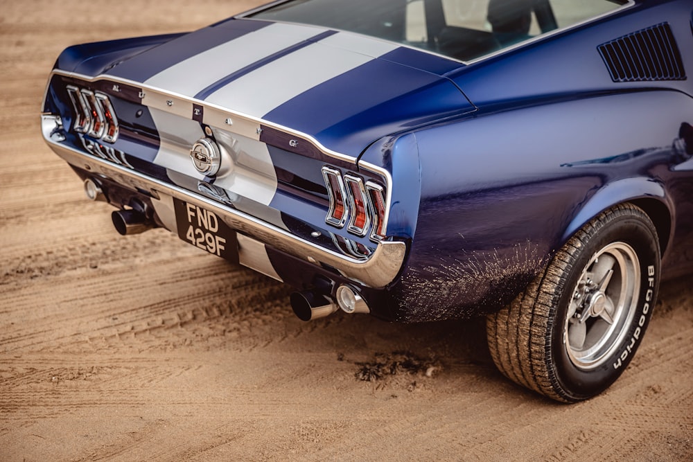 a close up of a blue car on a dirt road