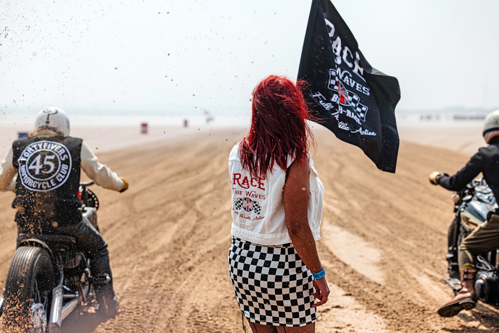 a group of people riding motorcycles on a dirt road