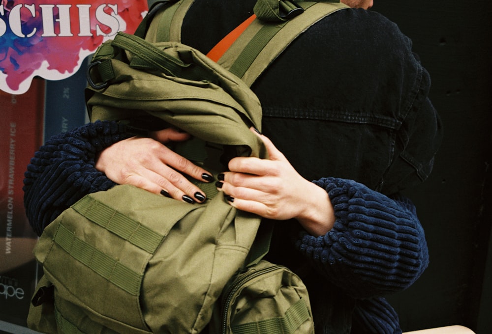 a woman is holding a backpack in her hands