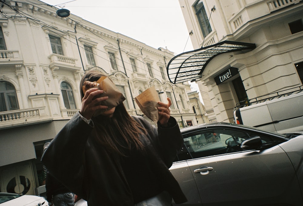 a woman holding a cup of coffee in front of her face