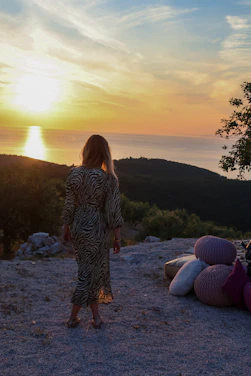a woman standing on top of a hill next to a pile of pillows