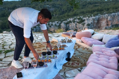 a man standing over a table filled with food