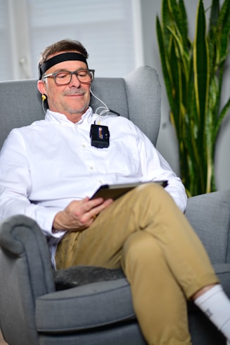 a man sitting in a chair wearing EEG headband