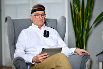 a man sitting in a chair with a tablet