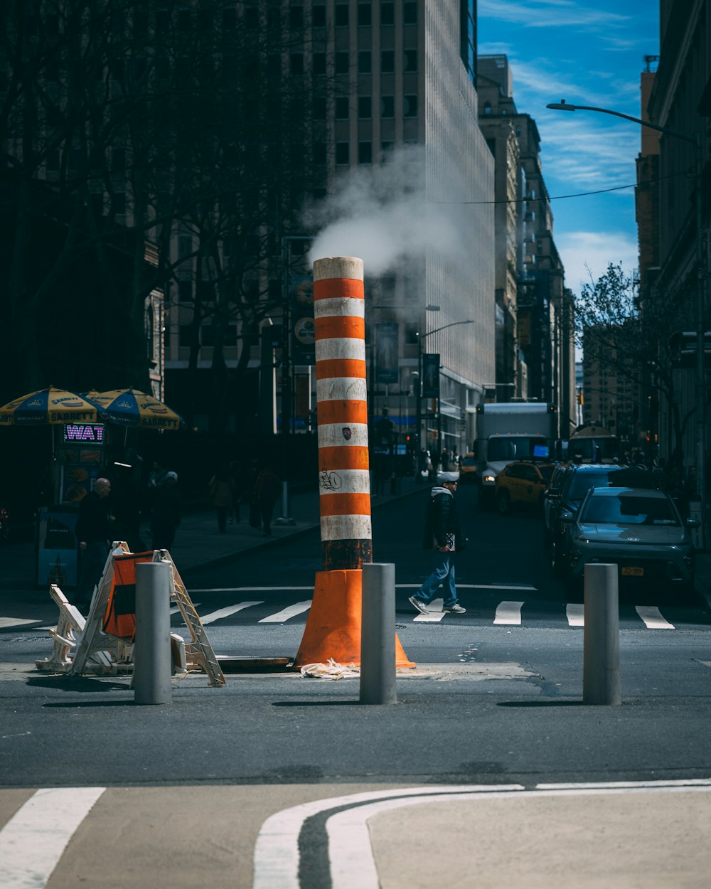 a city street with traffic cones and cars