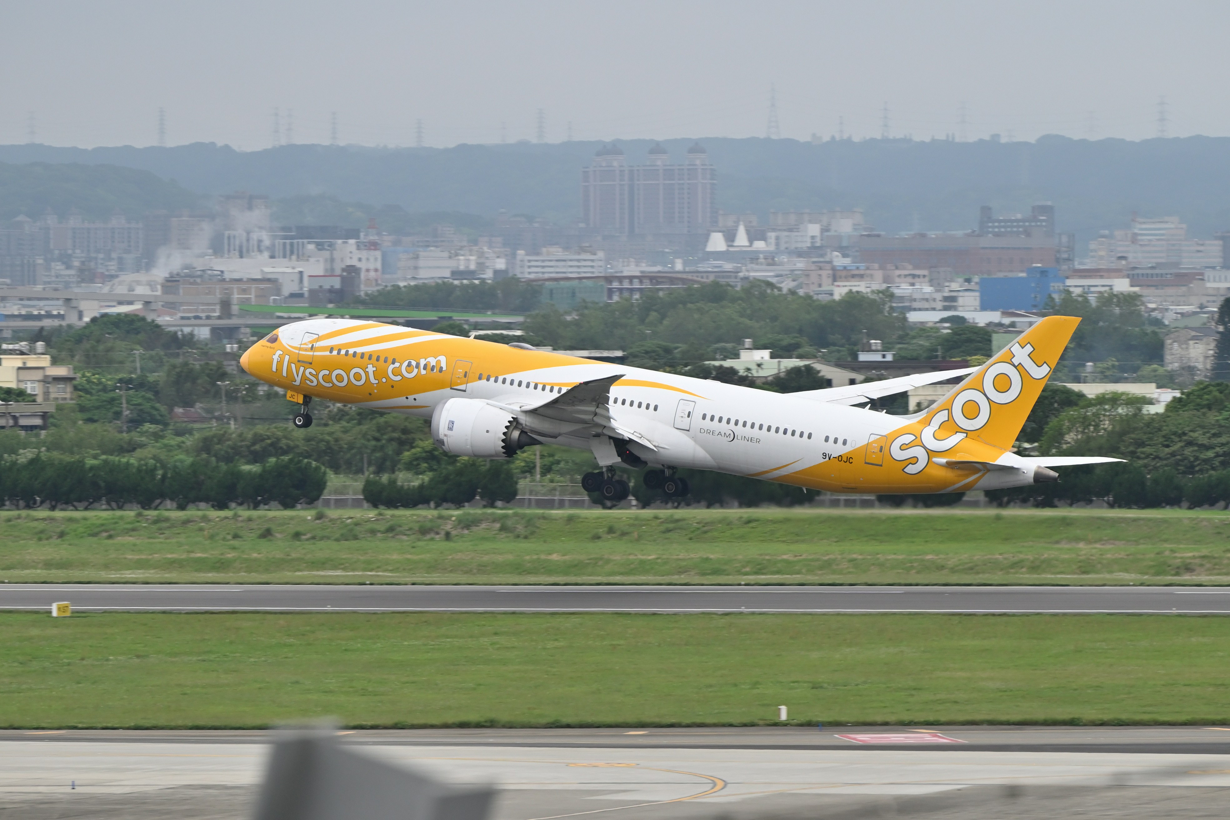 a yellow and white plane taking off from a runway, 